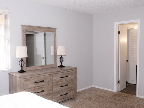 A bedroom with a bed, dresser, and mirror.