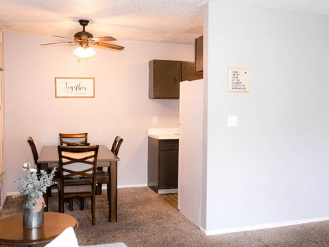 A dining room with a table set for two and a framed sign that says "together".