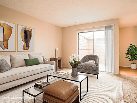 A living room with a couch, chair, and two paintings on the wall.