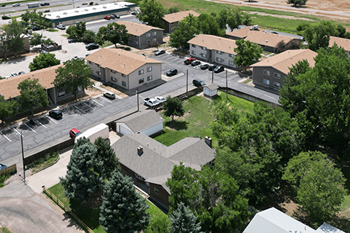A parking lot is surrounded by apartment buildings.