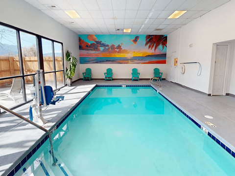 A large indoor swimming pool with a mural on the wall.