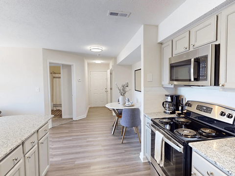 A kitchen with a stove top oven and a microwave above it.