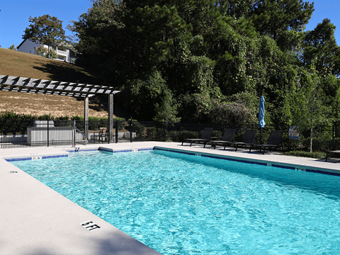 a swimming pool with black chairs and a resort style pool