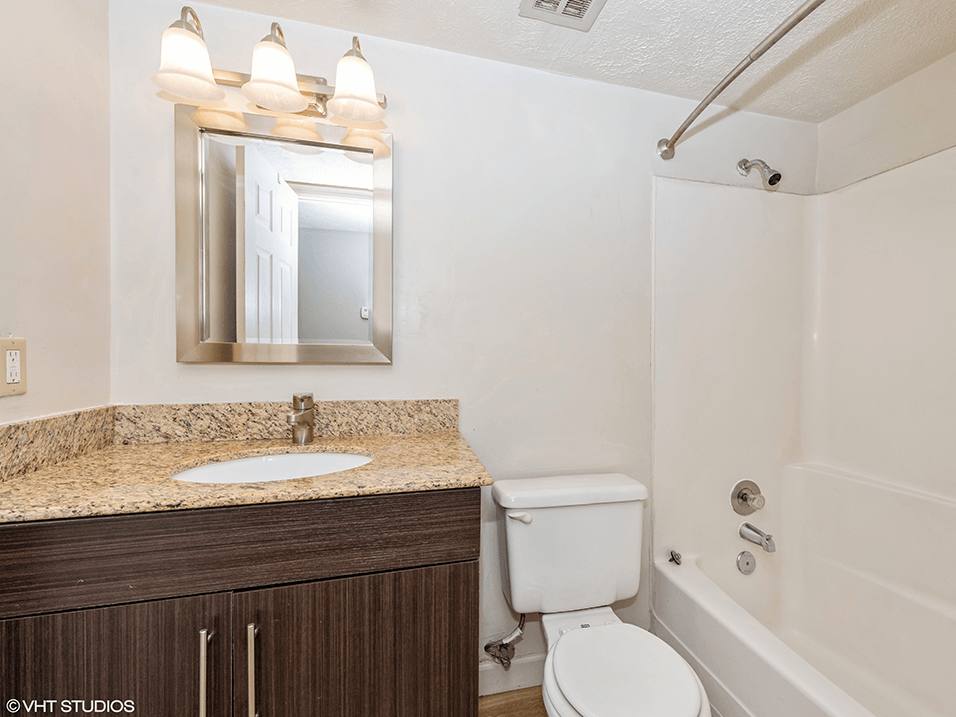 a bathroom with a toilet sink and shower and a mirror