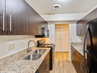 a kitchen with wood cabinets and granite counter tops and a sink