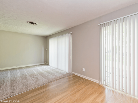 the living room and dining room of an apartment with white blinds on the windows