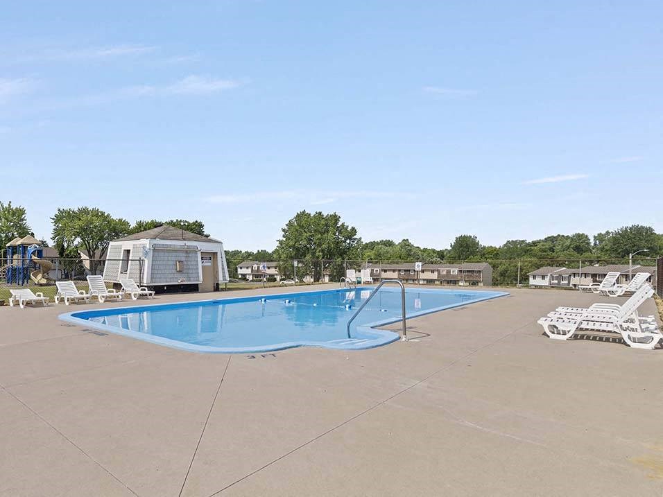 a large swimming pool with lounge chairs around it
