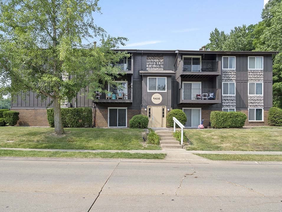 a large apartment building with a tree in front of it