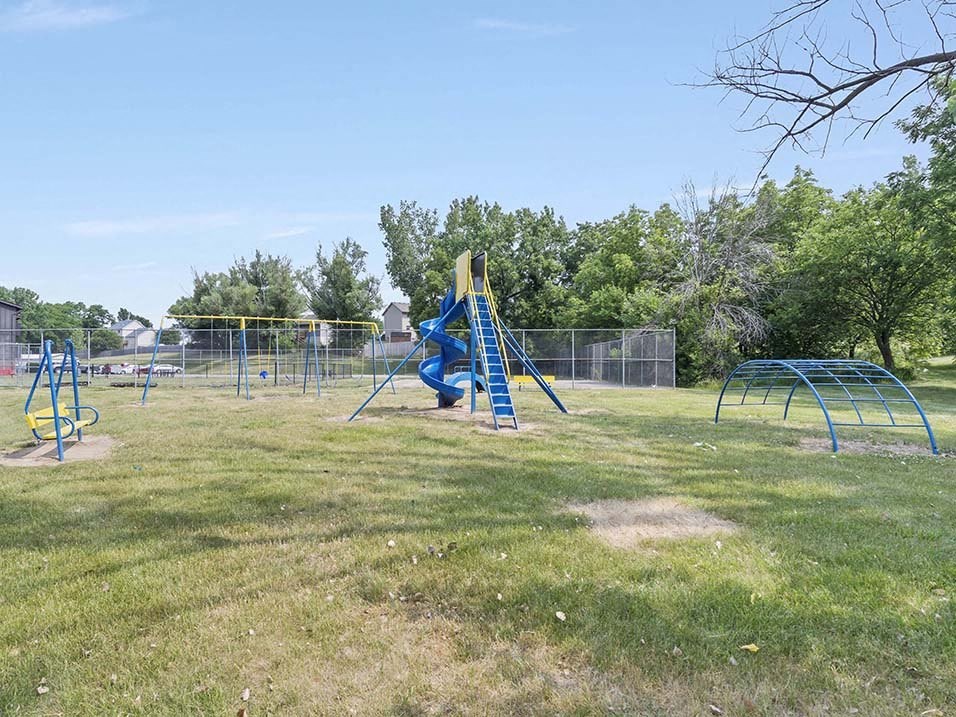 a playground with a swing set and monkey bars