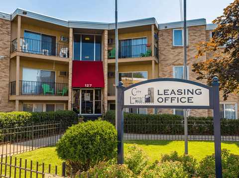 a leasing office sign in front of an apartment building