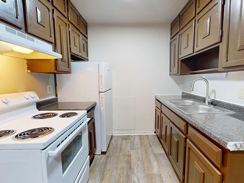 A kitchen with a white stove and brown cabinets.