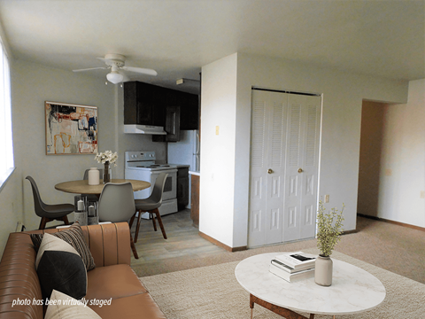 A living room with a brown leather couch and a white coffee table.