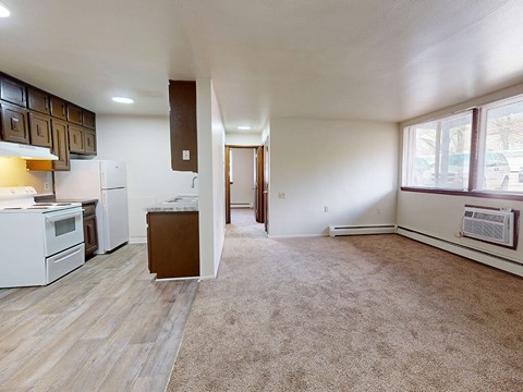 A kitchen with white appliances and wooden cabinets.
