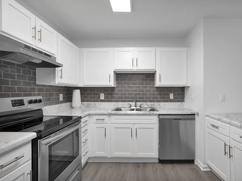A kitchen with white cabinets and a black stove top oven.