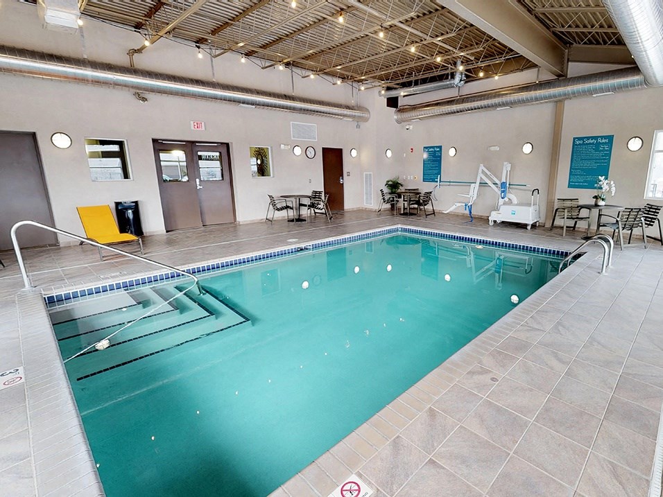 a large indoor swimming pool with chairs and tables