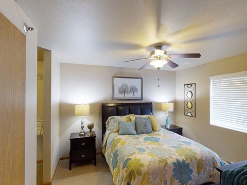 a bedroom with a bed and a ceiling fan