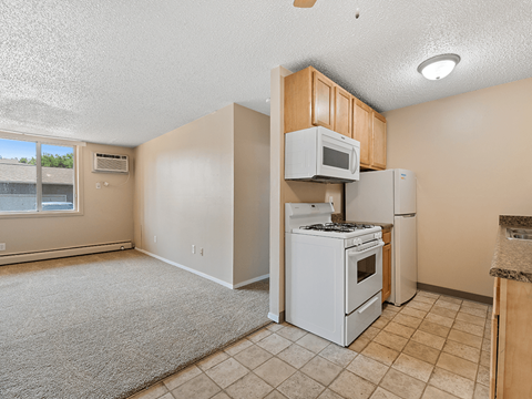 A kitchen with a white stove and refrigerator.