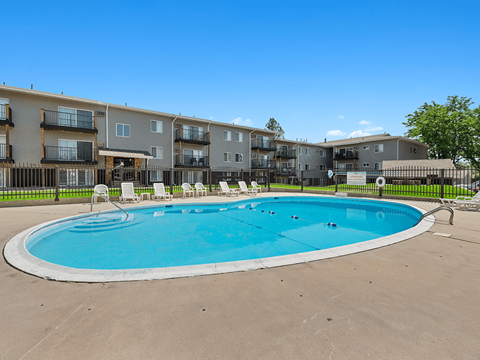 A large swimming pool in front of apartment buildings.