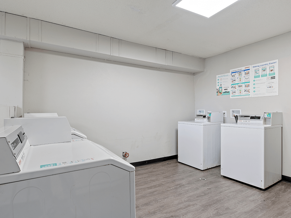 apartment complex laundry room with washes and dryers