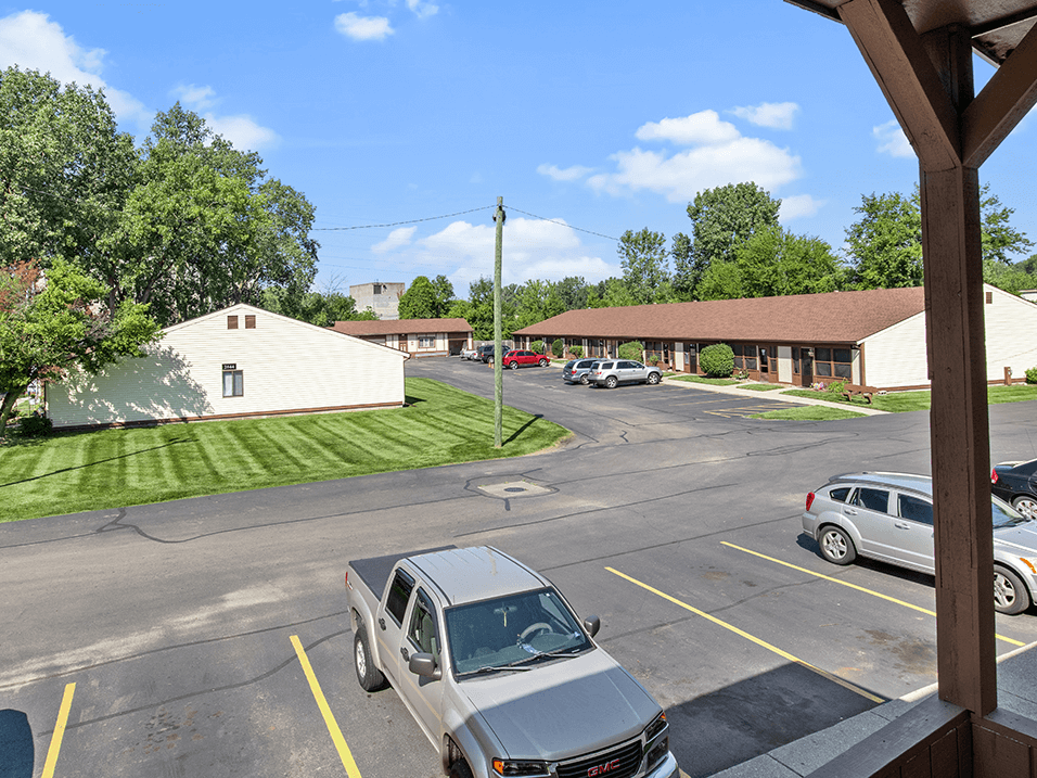 a parking lot with cars by an apartment building