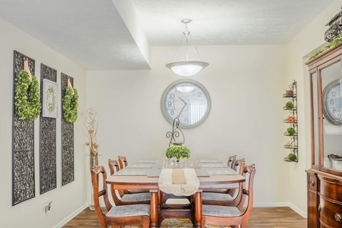 A dining room with a table set for six people.