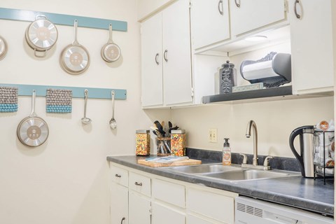 A kitchen with a white counter and a sink.