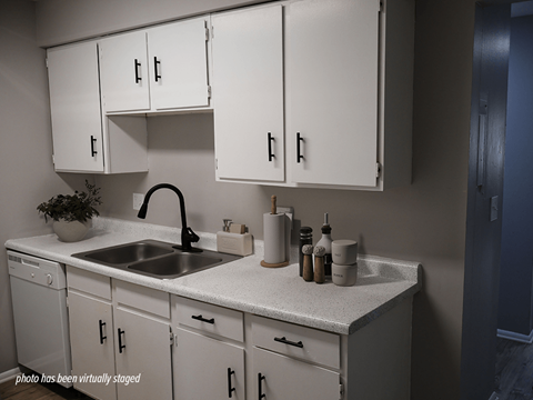A kitchen with white cabinets and a sink.
