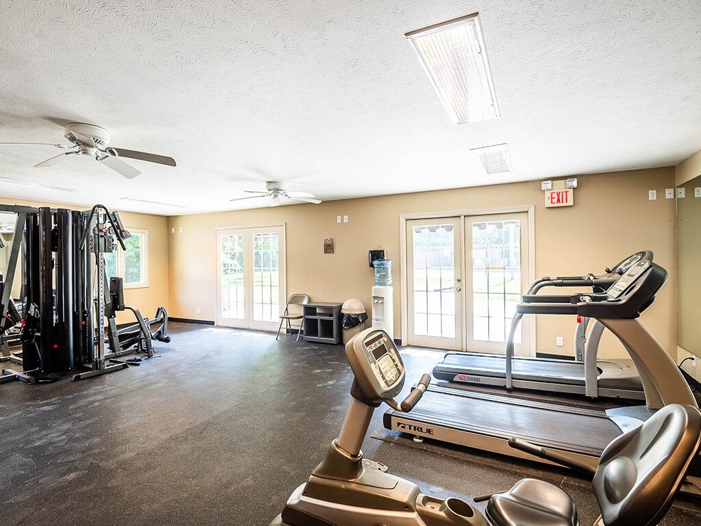 Apartment fitness center with treadmills, weights, and exercise equipment
