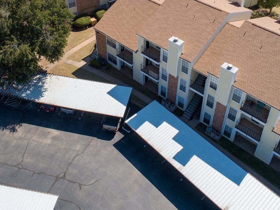 an aerial view of an apartment building with a blue and white roof
