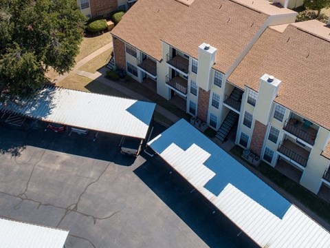an aerial view of an apartment building with a blue and white roof