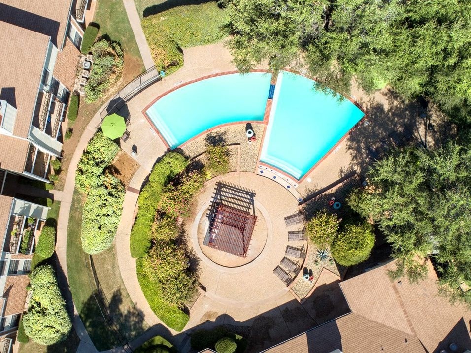an aerial view of a swimming pool and a patio with a bench