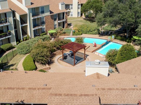 an aerial view of a pool and a courtyard with an apartment building