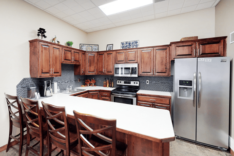 A kitchen with wooden cabinets and a white table.