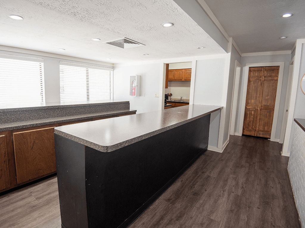 Clubhouse kitchen with a black countertop and wooden cabinets.