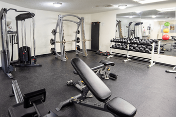 A gym with a variety of equipment including a leg press machine.