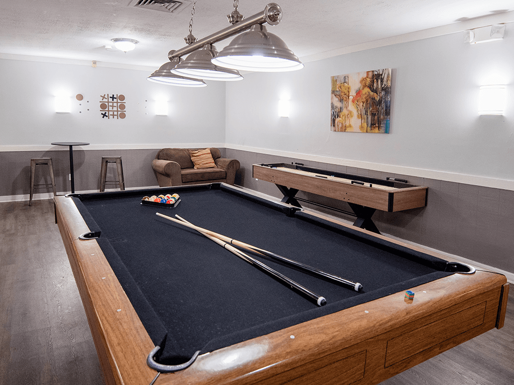 A pool table in a room with a light hanging from the ceiling.