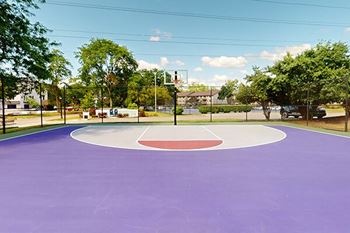 a purple basketball court in a park