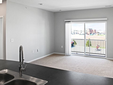 A kitchen with a sink and a view of the outside.