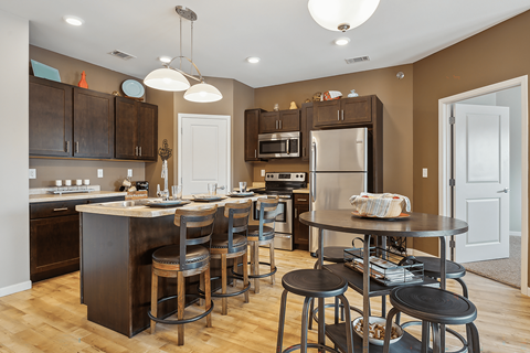 A kitchen with a table and chairs in the middle.