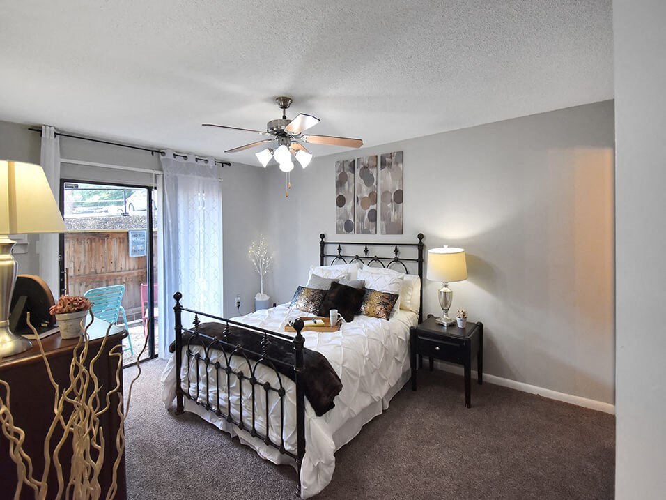 spacious bedroom with ceiling fan and large window