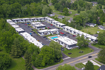 A bird's eye view of a residential area with houses and a swimming pool.