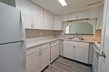 a kitchen with white cabinets and a sink and refrigerator