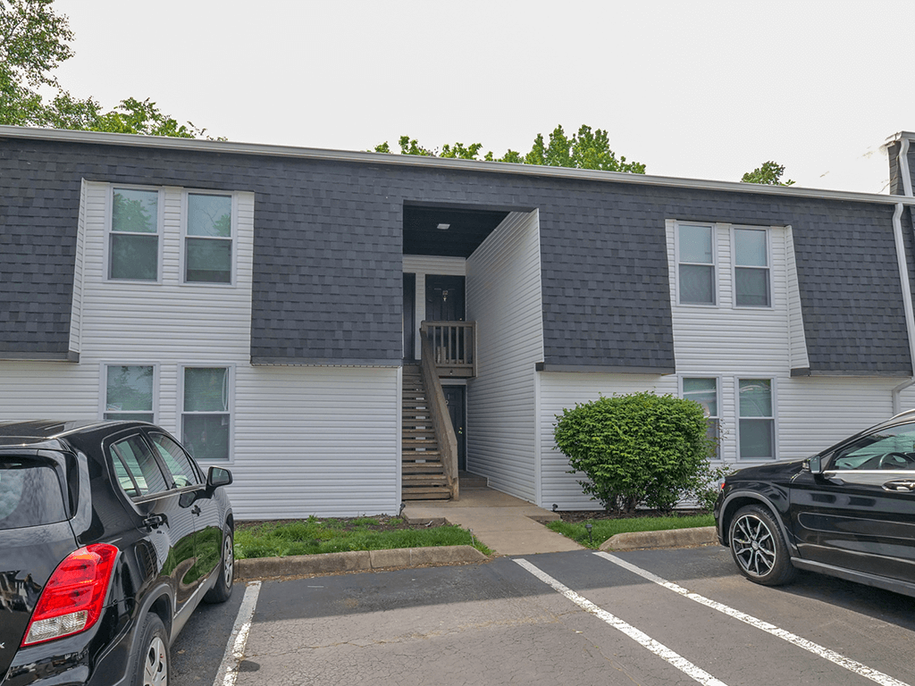 an apartment building with cars parked in front of it