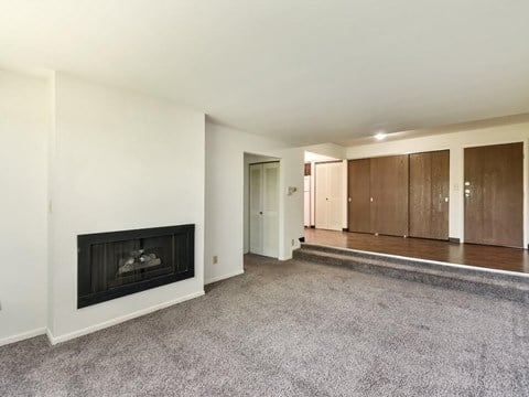 a living room with a fireplace and a carpeted floor
