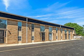 A long building with a black roof and windows on the side.