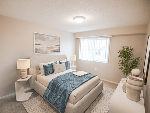 A bedroom with a bed, nightstands, and a plant.