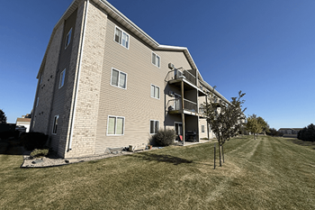 A large apartment building with a tree in front of it.