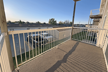 A car is parked on the street behind a fence.