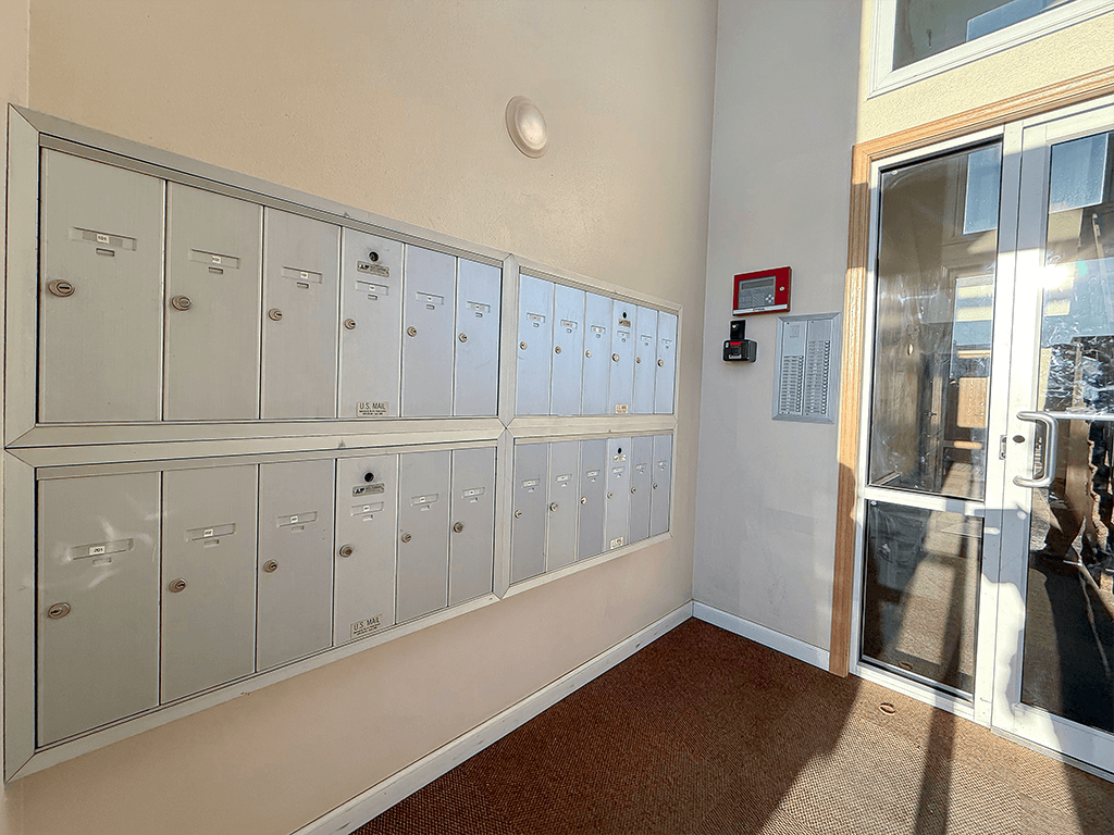 A row of white lockers are lined up against a wall.