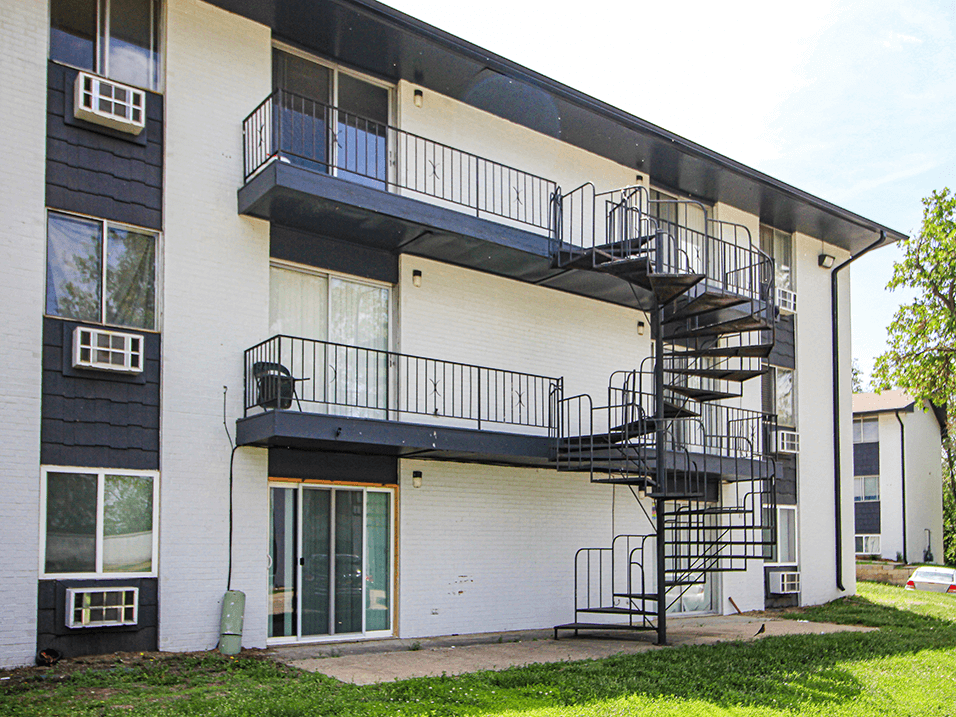 an exterior view of an apartment building with a spiral staircase